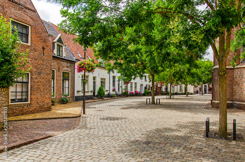 Hattem, The Netherlands, July 22, 2026: little square next to the church, with cobblestone pavement, trees and brick and plaster facades