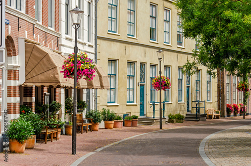 Hattem, The Netherlands, July 22, 2026: gently curving street in the old town with brick and plaster facades, cobblestone pavement and lamppost decorated with flowers