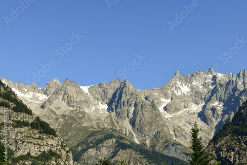 Scenic landscape of the rugged rocky peaks of the Mont Blanc massif under a clear blue sky during summer, Courmayeur, Aosta Valley, Italy