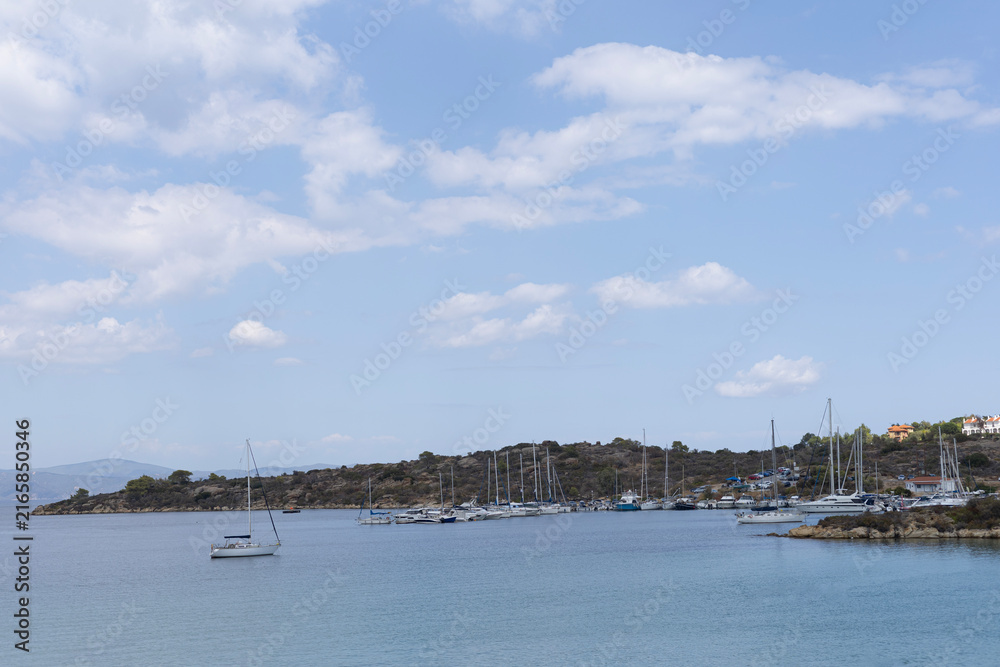 Obraz premium Mediterranean coastal harbor with sailboats and white buildings