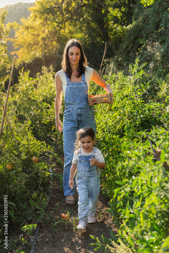 Mother and child stroll through vibrant garden paths