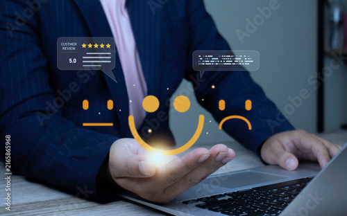 Canvastavla Customer experience management, excellent service feedback, and user review concept with businessman using laptop cupping glowing yellow smiley face icon and 5-star review bubble