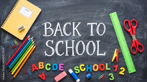 Back to School text written on a chalkboard with colorful school supplies and stationery