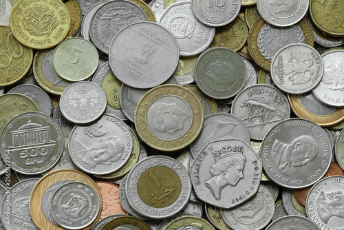 Pile of global currencies, various coin types visible up close. Different nations money together