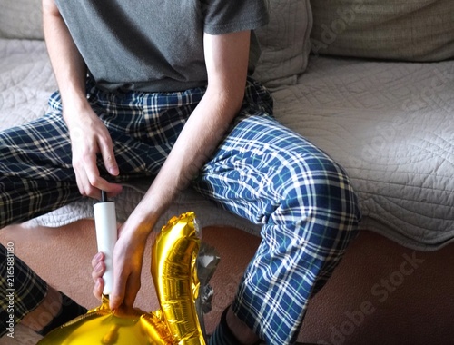Canvastavla Person inflating shiny golden foil balloon using a hand pump on a soft surface