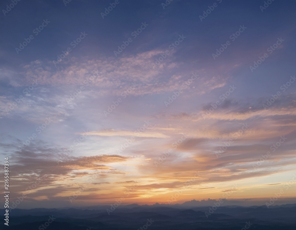 Fototapeta premium A calm and tranquil view of a colorful sunset sky with shades of pink, orange, and blue, enhanced by soft, scattered clouds creating an enchanting atmosphere for relaxation and contemplation, AI generated