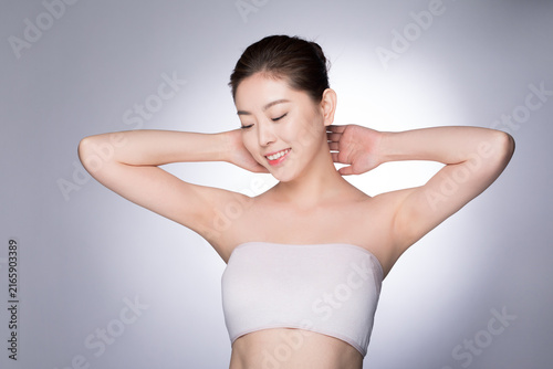 Konstfotografi Young woman smiling with raised arms in clean beauty skincare portrait