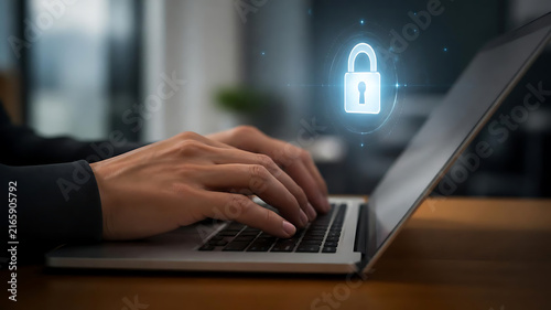 Professional typing on a laptop with a digital security padlock icon floating as an abstract cybersecurity protection concept in a modern office