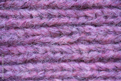Purple wool knit texture background Macro close-up of purple knitted wool fabric with soft fuzzy yarn and visible stitch pattern. Cozy warm textile texture in rich violet tones, ideal for fashion, win