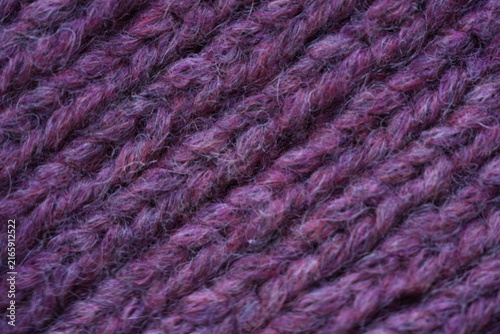 Purple wool knit texture background Macro close-up of purple knitted wool fabric with soft fuzzy yarn and visible stitch pattern. Cozy warm textile texture in rich violet tones, ideal for fashion, win