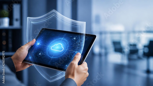Professional person holding tablet with cloud icon and digital shield for cyber security and data protection in modern office