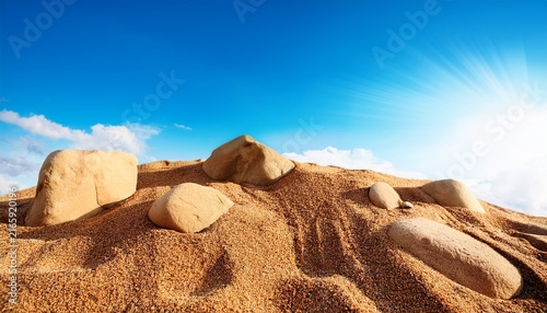 Earth Sand With Stones On The Background Of Blue Sky In Summe