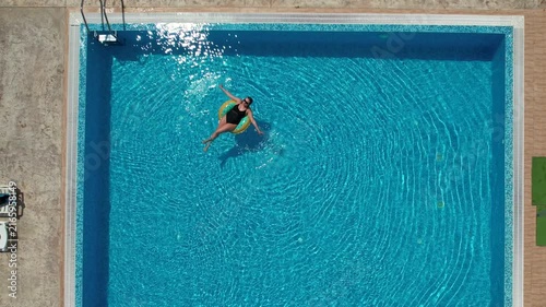 Woman on inflatable donut pool float in pool in hotel. Summer holidays, enjoying summer vacations

