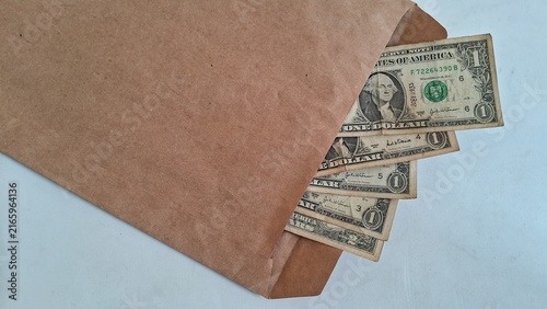 фотографія Brown paper envelope containing several crumpled one dollar american bills