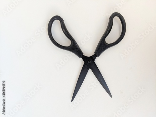 Black scissors isolated on white background highlighting simple household cutting tool.
