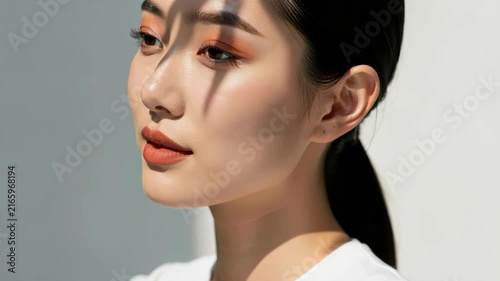 Sun-Kissed Elegance: A young woman with flawless skin and striking makeup gazes away, bathed in the dappled sunlight casting playful shadows across her face, embodying a serene and alluring beauty.