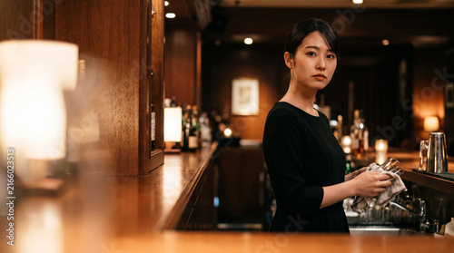 Plakat w ramie バーのカウンターでグラスを磨く日本人女性スタッフ