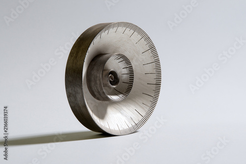 Metal ruler curled into a spiral shell surreal geometry concept