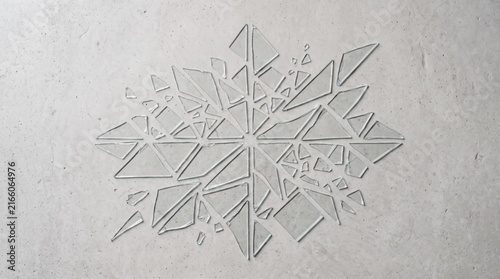 Abstract geometric snowflake pattern made of triangular shards embedded into a textured grey concrete wall, representing winter design, architectural detail, minimalist art