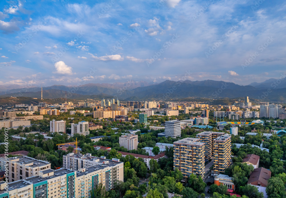 Fototapeta premium A picturesque drone view of the Kazakh city of Almaty at sunset on a summer evening.
