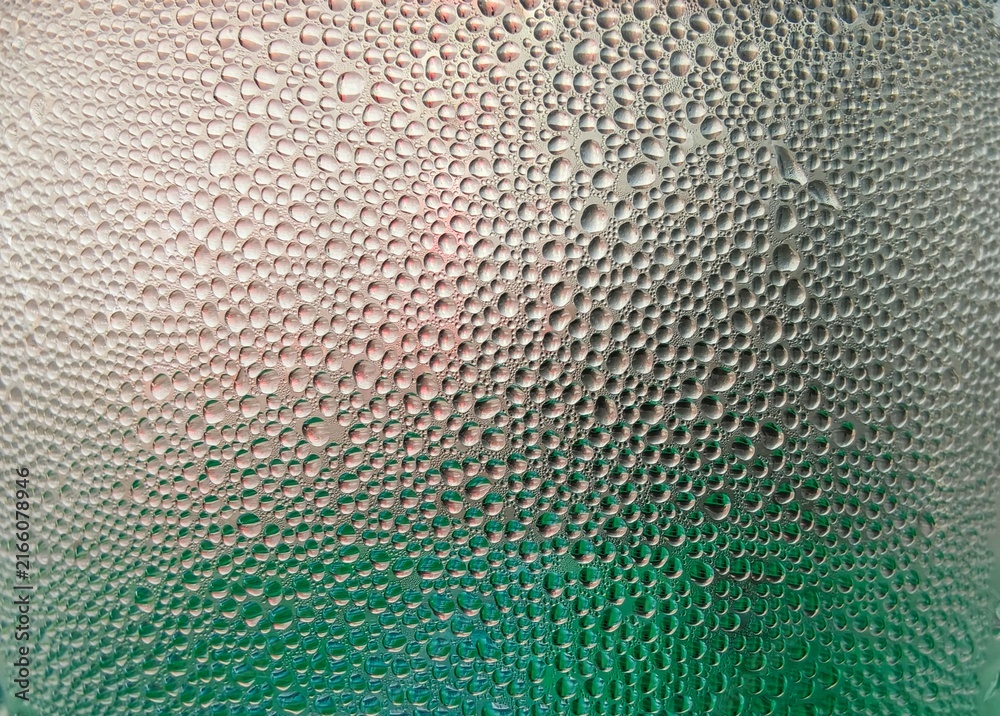 Obraz premium Background texture of stagnant water droplets. Condensate droplets on the surface of a plastic bottle, close-up view. Background of water drops on glass