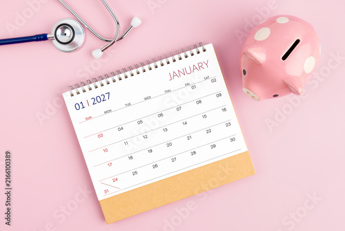 January 2027 desk calendar and stethoscope with piggy bank, Savings for Health insurance concept.