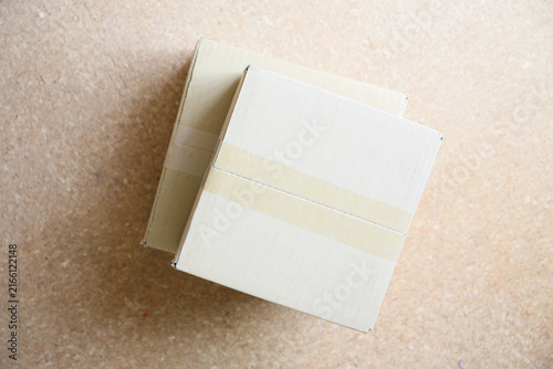 two cardboard postal packaging boxes standing on a floor
