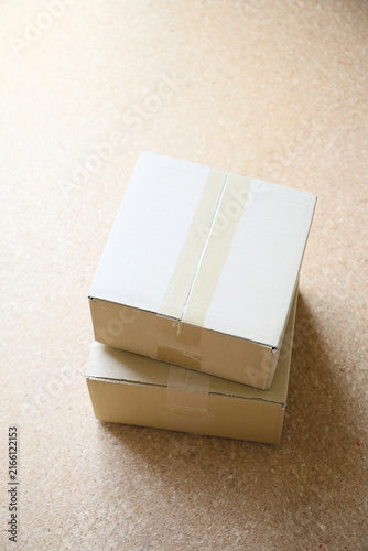 two cardboard postal packaging boxes standing on a floor