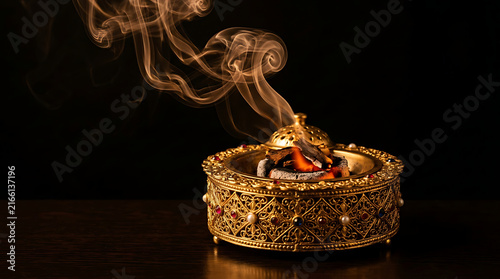 Burning incense in a golden burner for spiritual or decorative use