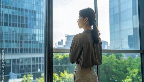 オフィスで窓の外を見る女性会社員	
