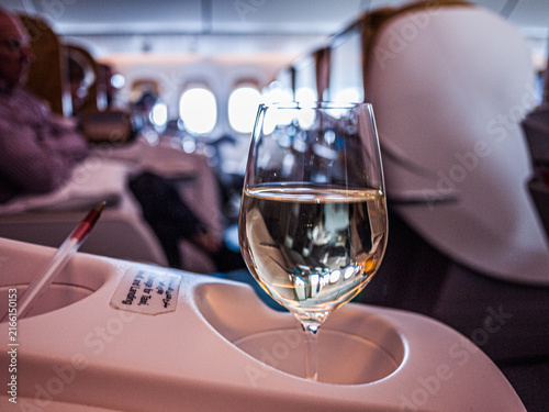 SINGAPORE - SEPTEMBER 26, 2012: Glass of white wine in Business Class cabin onboard an Emirates flight from Singapore to Brisbane, Australia