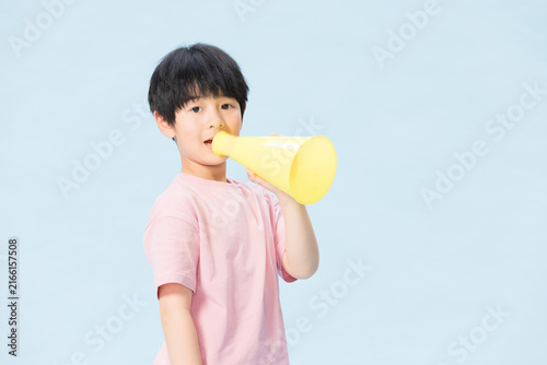 фотографія Boy with Yellow Megaphone on Blue Background