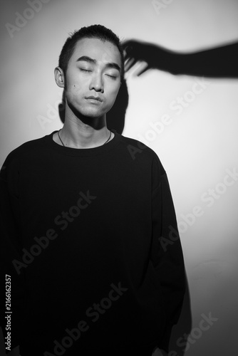 Konstfotografi Moody black and white portrait of a young man with shadow hand