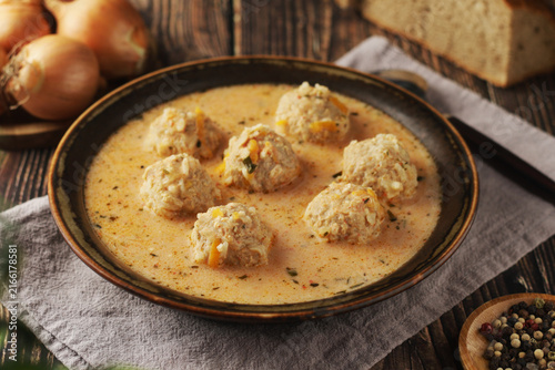 A bowl with traditional Romanian soup Ciorba de perisoare with meatballs	