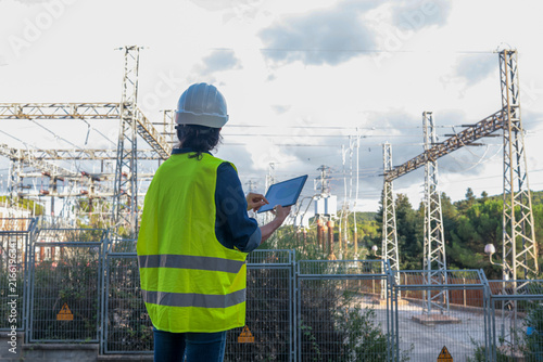 Quadro su tela Engineer working on electrical substation infrastructure, holding a digital tabl