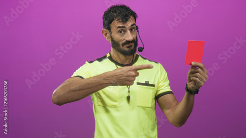 Canvas Print Man referee points finger and shows red card in studio wearing uniform and whistle; authority discipline judgment