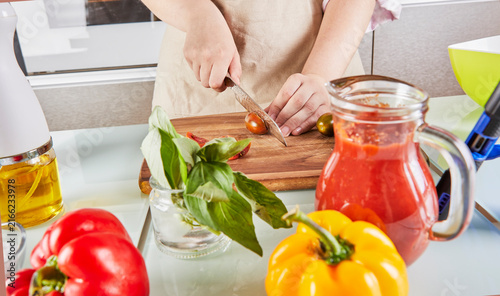 Foto Teenager prepare spaghetti bolognese from an online textbook and watches digital recipe on touchscreen tablet while preparing healthy meal in the kitchen at home