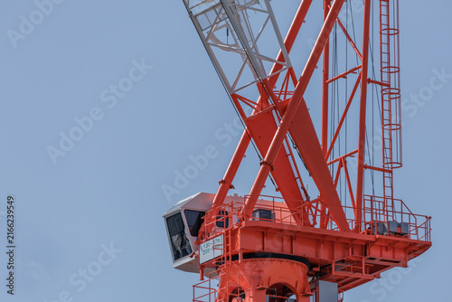 Cuadro en lienzo Luffing jib tower crane cabin and slewing platform set against a clear blue sky in Japan