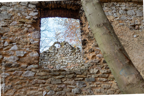 Autumn woodland and crumbling masonry seen through a historic window opening in the ruins near Devil’s Bridge in Czerna, Lesser Poland. Detail of the former Carmelite complex in picturesque Eliaszówka