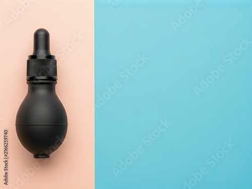 Black matte serum bottle with dropper on pastel pink and blue background for cosmetic product mockup