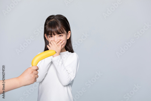 Fotografía Little girl refusing banana with hand over mouth
