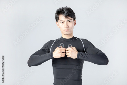 Canvastavla Athletic man exercising with hand grippers in studio