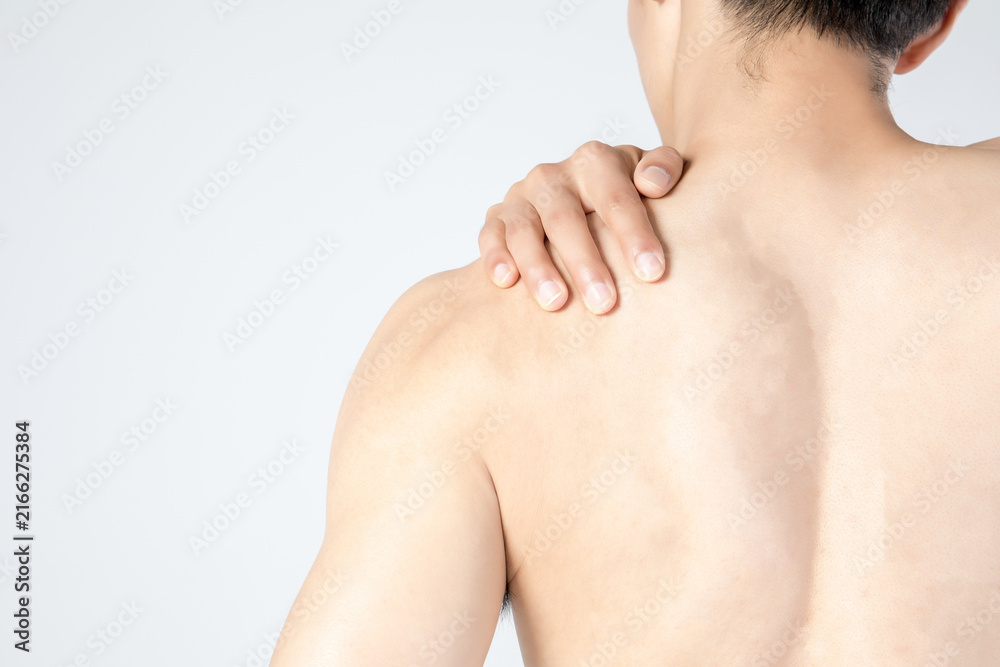 Naklejka premium Shirtless man holding painful shoulder from behind