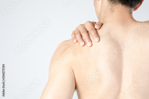 Shirtless man holding painful shoulder from behind