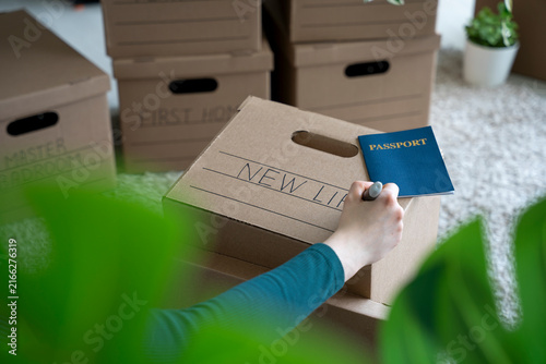 Obraz na płótnie Writing “New Life” on Moving Box with Passport