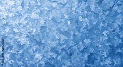 Close-up macro texture of frosted ice crystals forming intricate patterns on a blue background