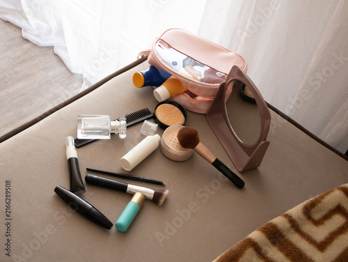 Foto Beige flat lay with pink makeup bag and cosmetics scattered under daylight