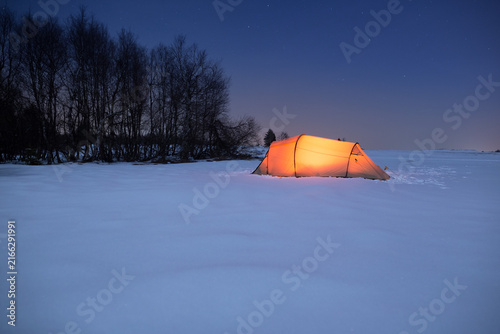 Illuminated tent under a clear sky in winter