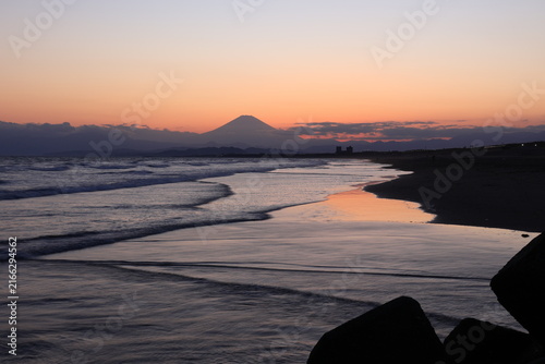 Plakat 鵠沼海岸にて、日没後のオレンジ色に染まる波打ち際と富士山と人のシルエット 夕景