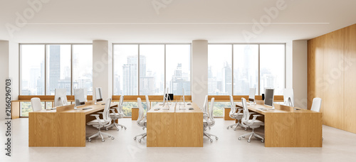 Contemporary open plan office interior design with wood workstations, ergonomic chairs, computers, and panoramic city windows. 3D Rendering